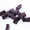 Dark purple gummy bears with sugar coating on white background.