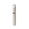 Tall, light beige portable spice grinder with a small viewing window and textured finish.