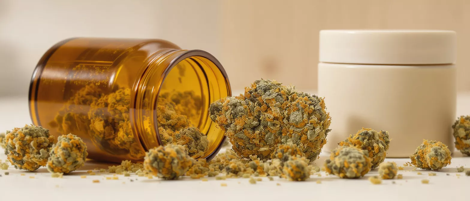 Cannabis buds spilling from an amber jar, with a white container nearby.