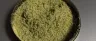 Fine golden kief powder collected in a grinder chamber