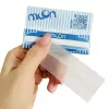 Hand holding a blue and white packaging with a transparent strip.