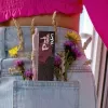 Pink paper pack and wildflowers peeking from a denim pocket.